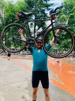 Me hoisting my bike above my head at the finish line of the 2022 Seattle to Portland ride.